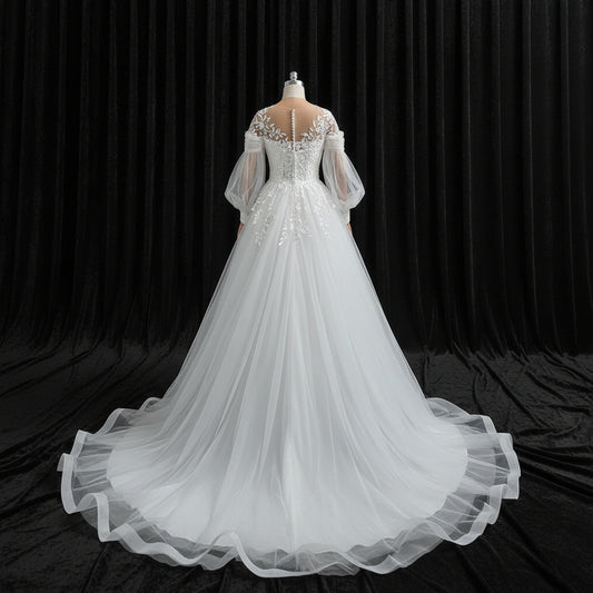 Elegant Christian bridal ball gown featuring illusion neckline, floral lace appliqués, and chapel train