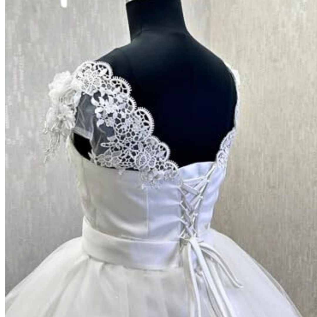 Embroidered white bridal ball dress with long sleeves and lace hem detailing