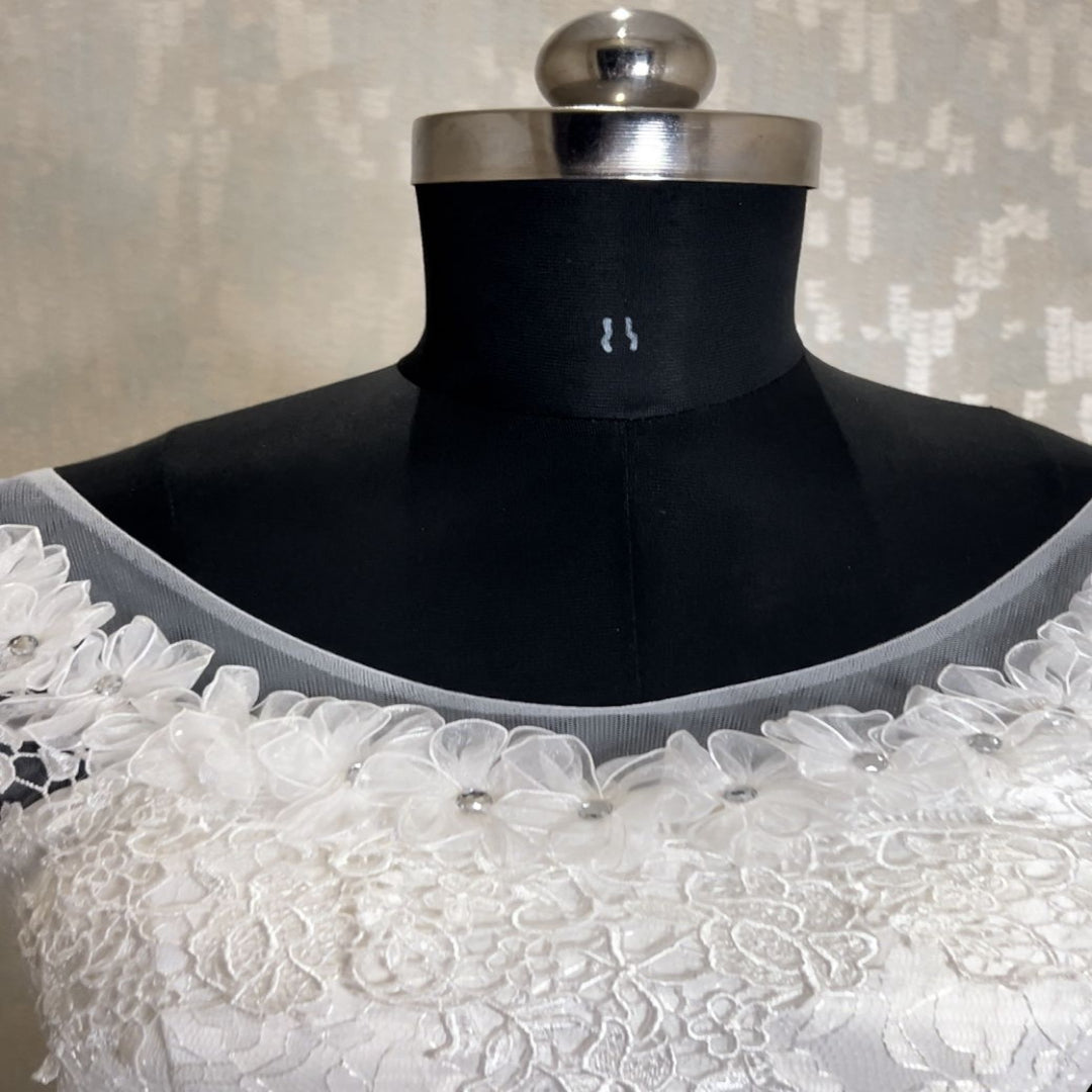 Timeless white wedding gown featuring floral lace embroidery and elegant tulle skirt