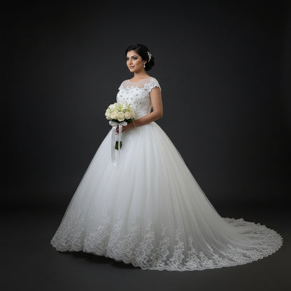 Christian bridal gown featuring delicate cap sleeves, floral lace appliqué, and a classic princess silhouette
