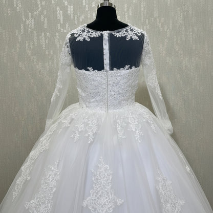 Christian wedding gown with long lace sleeves, illusion neckline, and floral lace hem