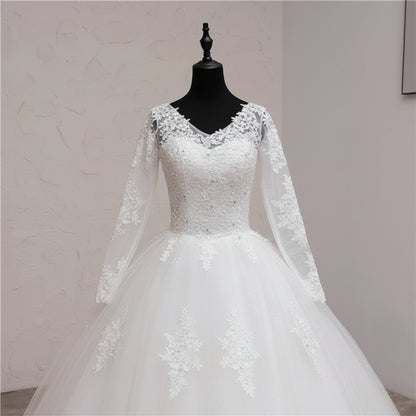 Designer Christian bridal gown with illusion lace sleeves, floral appliqués, and elegant cathedral train