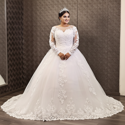 Designer Christian bridal gown with illusion sleeves, floral lace details, and luxurious tulle skirt