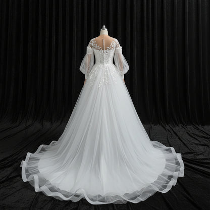Elegant Christian bridal ball gown featuring illusion neckline, floral lace appliqués, and chapel train