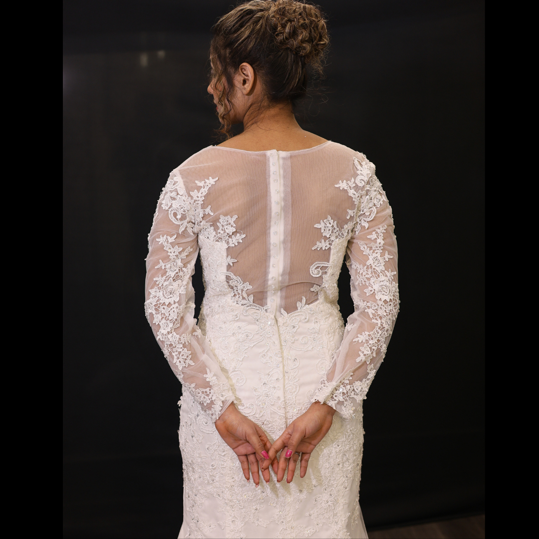 Elegant side-profile Christian bridal dress with lace sleeves, fitted bodice, and flowing lace train
