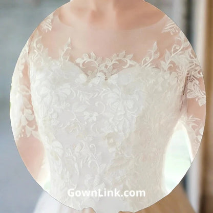 Floral lace bridal ball gown designed with illusion sleeves and detailed embroidered hemline