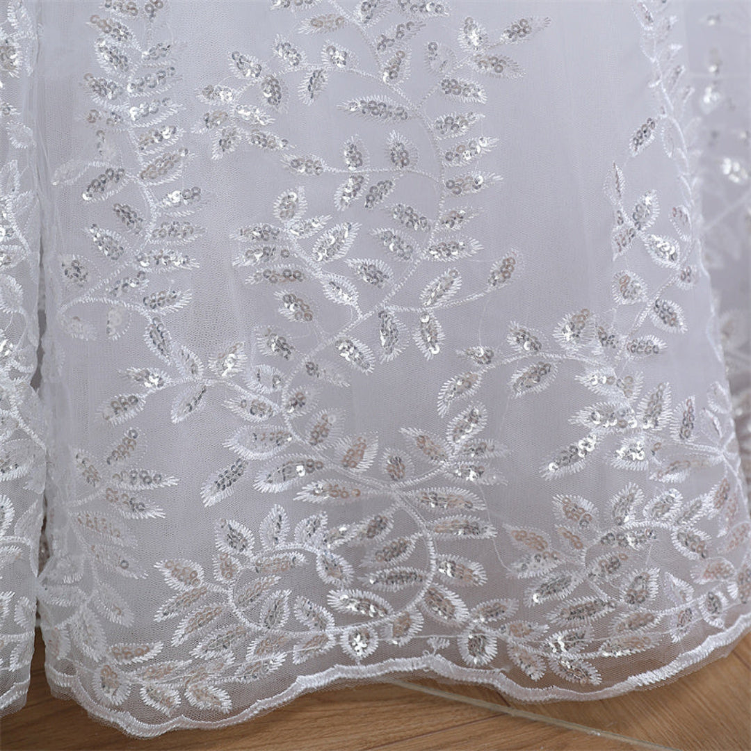 Layered Christian ball gown with floral lace appliqués and elegant cathedral-inspired design
