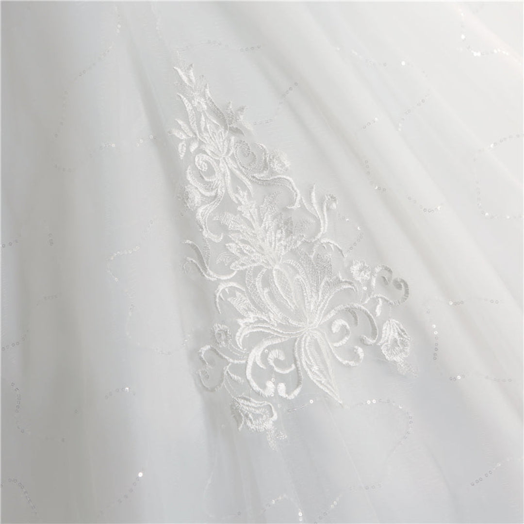 Princess-style Christian bridal gown in white with lace appliqués, fitted bodice, and sweeping train