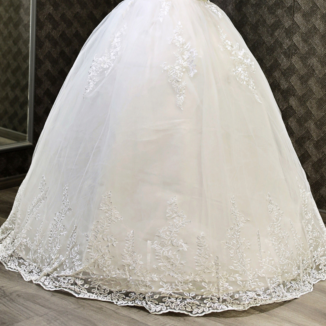 Romantic Christian bridal dress featuring sheer lace sleeves, floral embroidery, and a princess silhouette