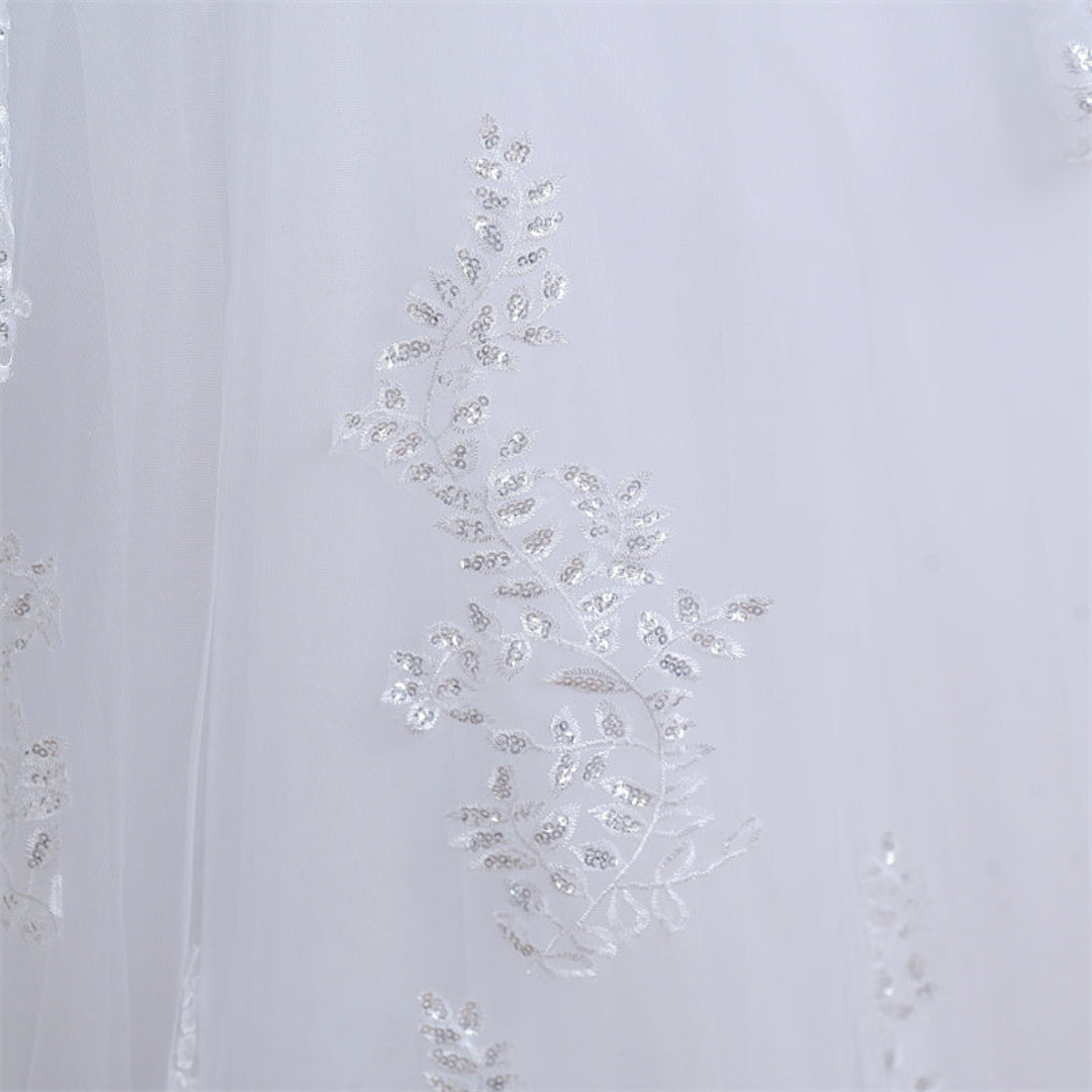 Romantic Christian bridal gown featuring lace embroidery, illusion sleeves, and full tulle skirt