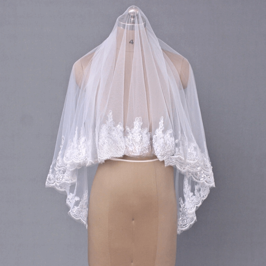 White tulle bridal veil with floral lace edge and comb
