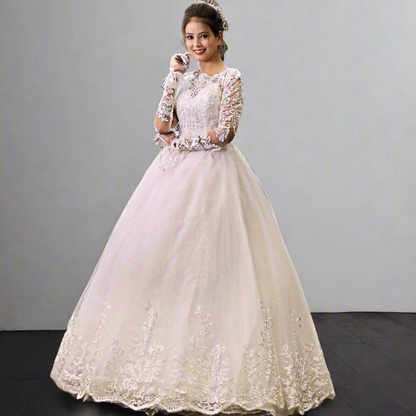 White Christian bridal dress with intricate lace bodice, illusion sleeves, and flowing tulle skirt