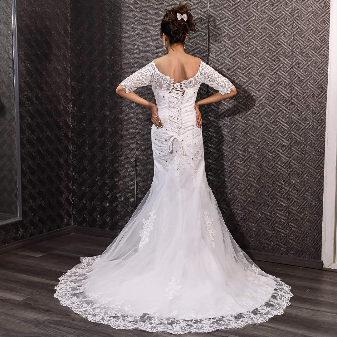 White mermaid bridal gown with floral lace appliqué and a romantic chapel train