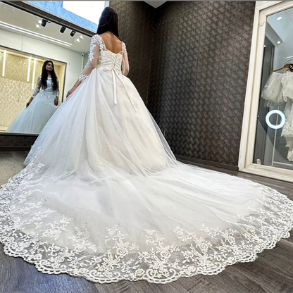 Front view of White Bridal Gown with Long Train on model against studio backdrop — GownLink GLHSD189T